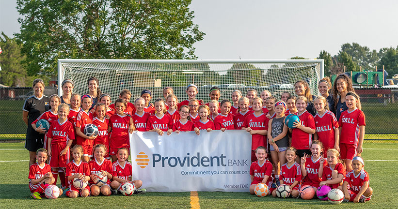 Youth Soccer team holding Provident Banner