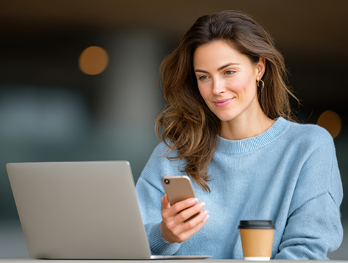 woman looking at laptop with coffee cup on the side