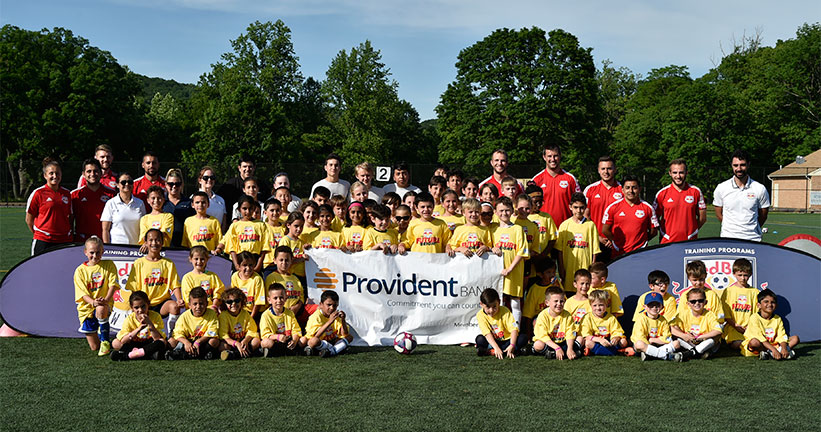 Youth soccer team holding Provident Banner
